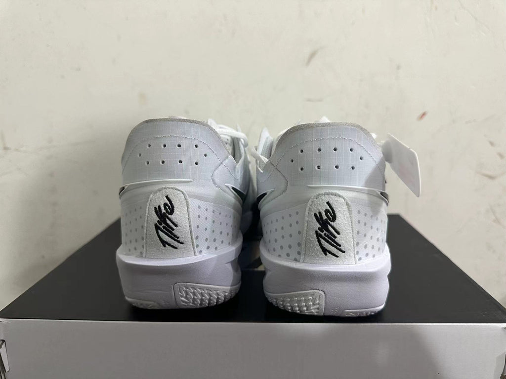 Rear view of white Nike basketball shoes with perforated heel panels and black details.