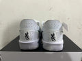Rear view of white Nike basketball shoes with perforated heel panels and black details.