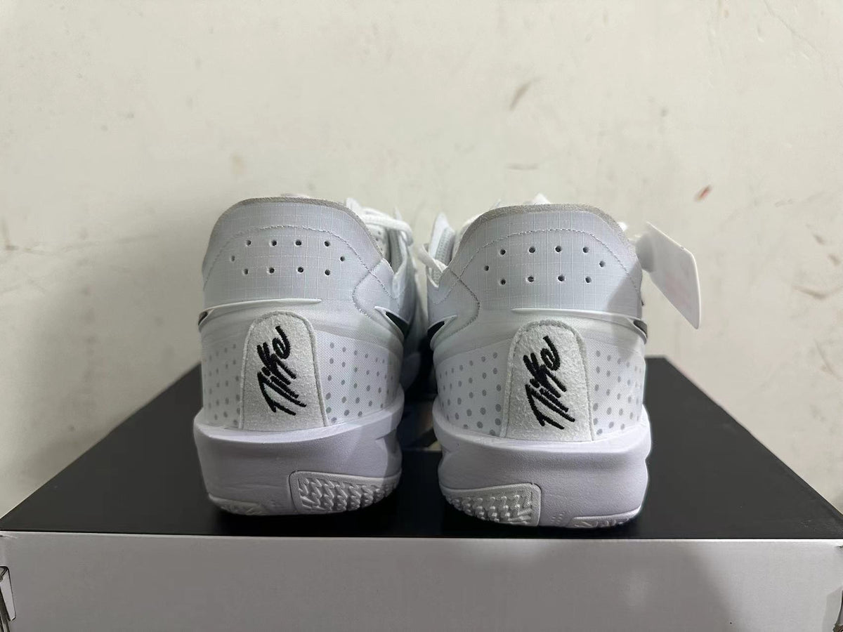 Rear view of white Nike basketball shoes with perforated heel panels and black details.