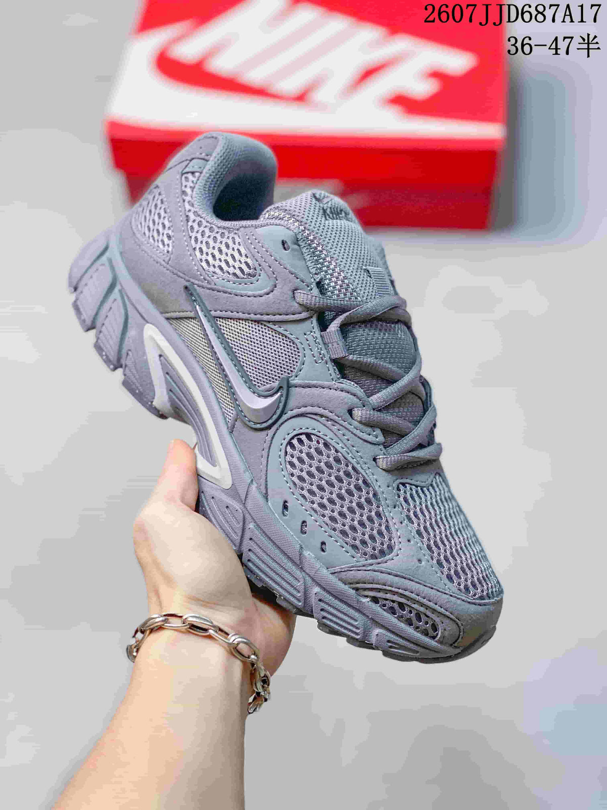 Angled side view of the gray Nike V5 RNR sneaker showing the mesh upper, swoosh, laces, and segmented outsole.