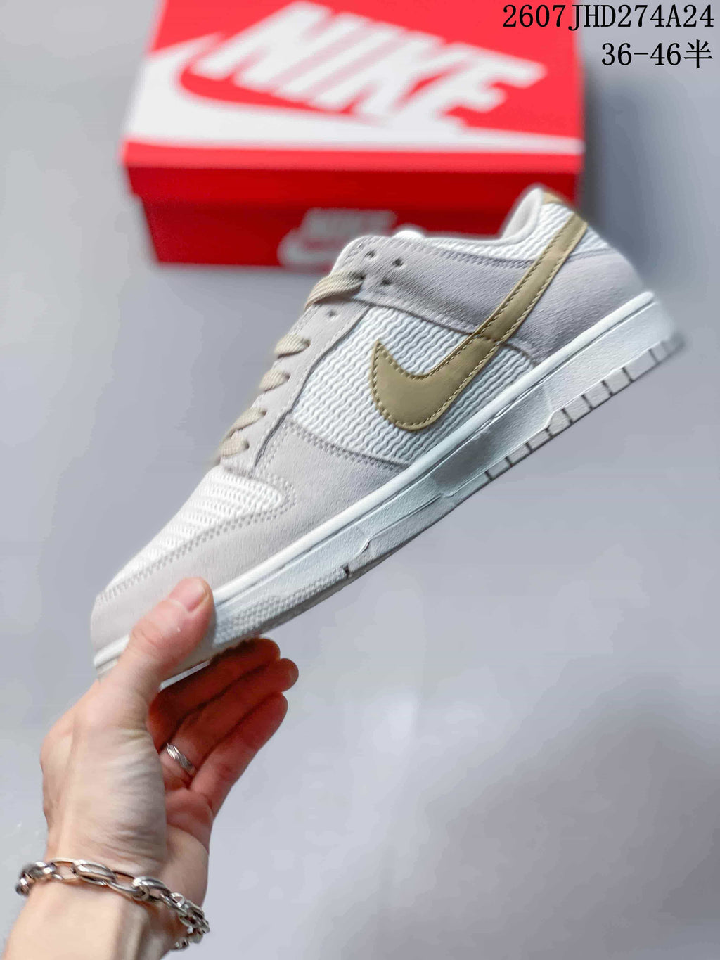 Side profile showing the white low-top sneaker, light gold Swoosh, textured panels, and white midsole.