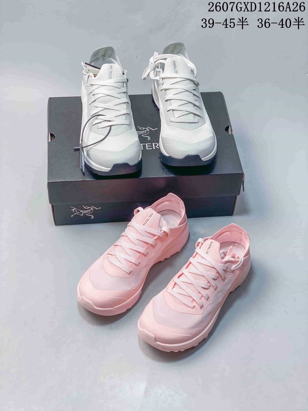 White and pink Arc'teryx Sylan shoes arranged together with a shoe box.