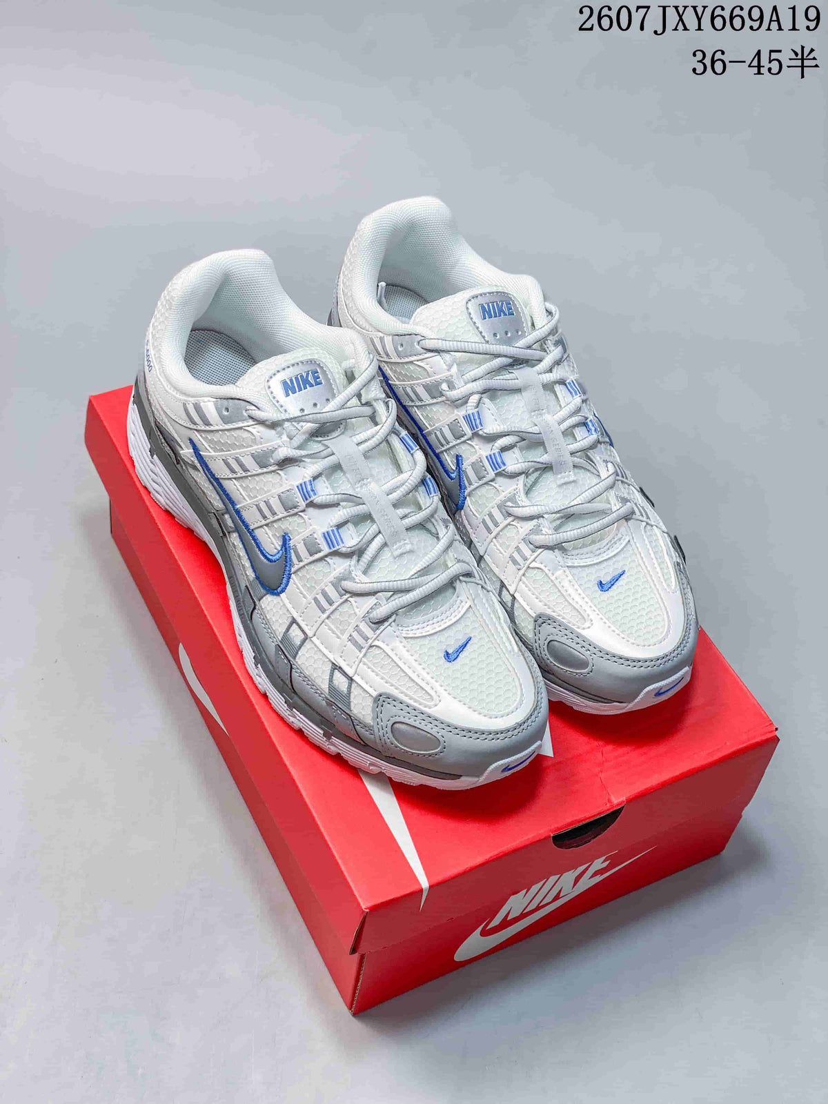 Pair of white, grey, and blue Nike sneakers displayed on a red shoebox; overlaid text shows a product code and the size range 36–45.5.
