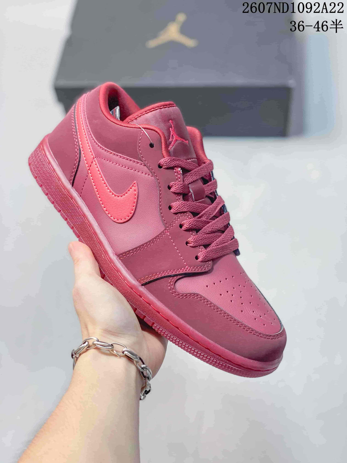 Monochrome pink low-top Jordan sneaker with matching laces, overlays, and outsole.