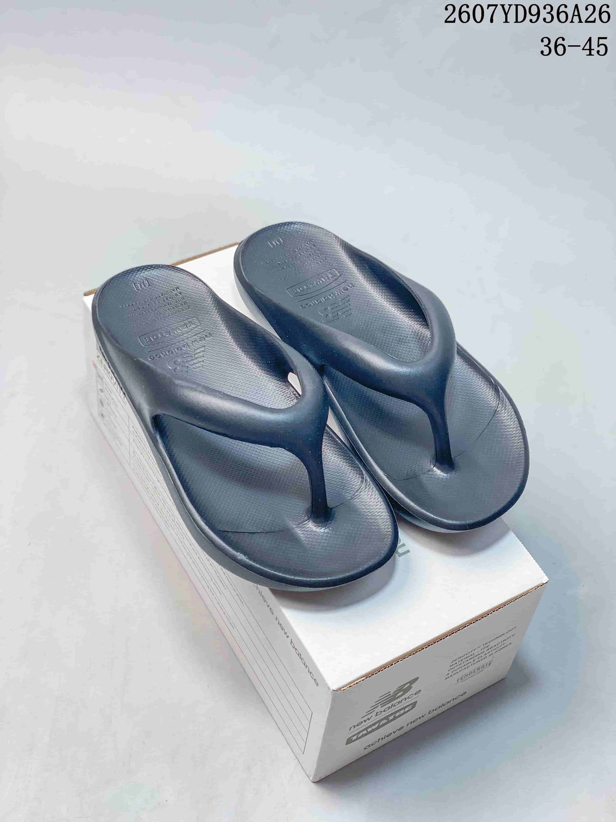 Pair of black New Balance NB5601 flip-flop sandals displayed on a shoe box; size range 36–45 is visible in the upper-right corner.