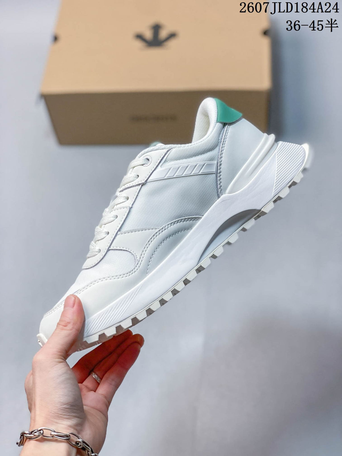 Side profile of the white low-top sneaker showing layered panels, padded collar, white midsole, and treaded outsole.