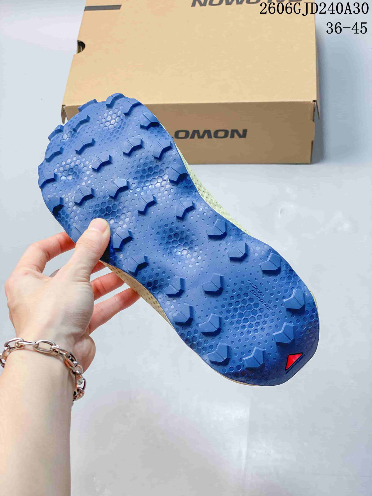 Blue lugged outsole of a Salomon Ultra Glide 4 trail running shoe.