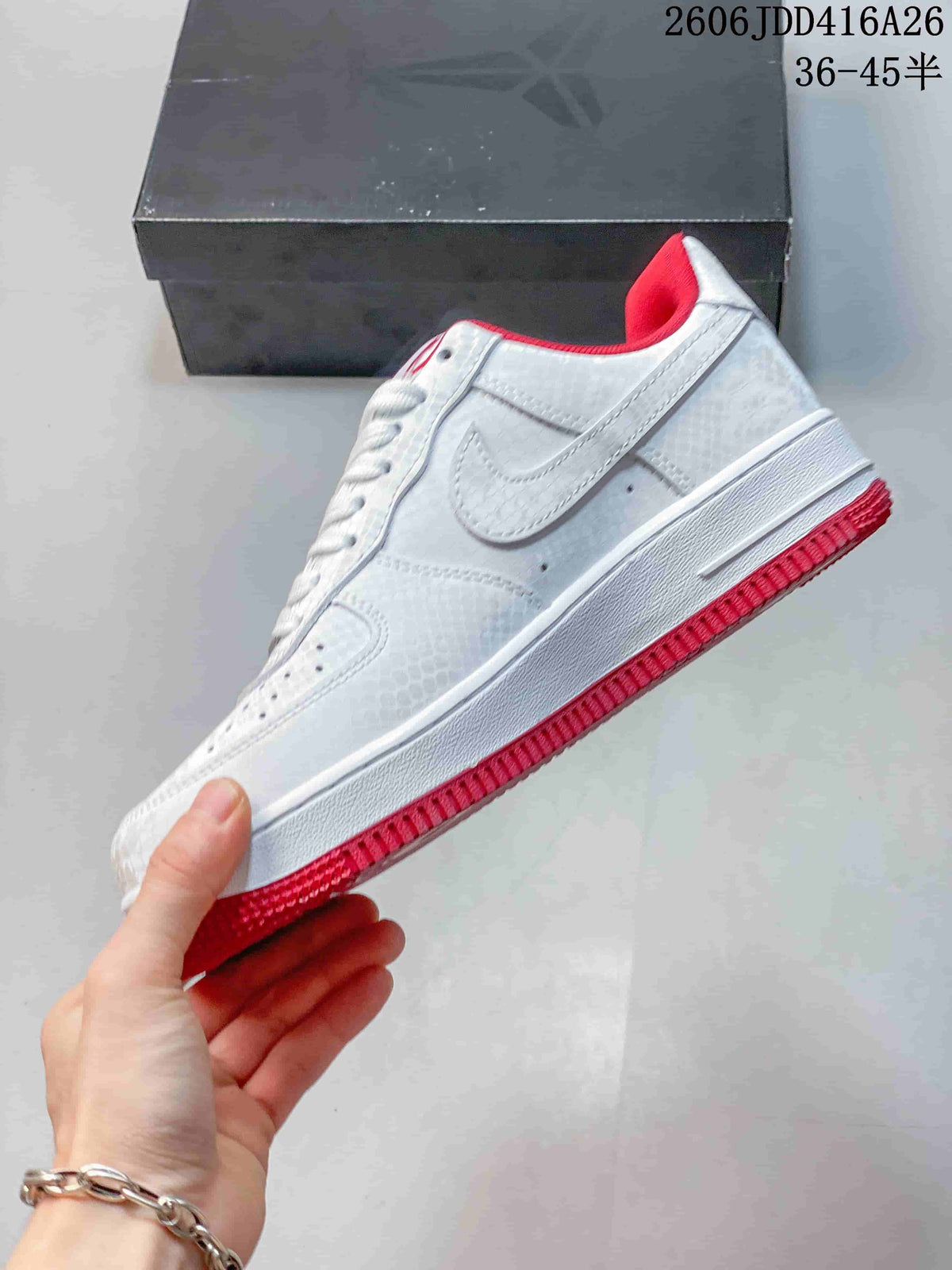 Side view of the white low-top sneaker with a red outsole and collar lining.