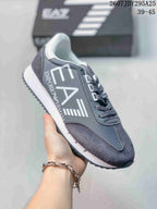 Close-up of a gray Emporio Armani EA7 lace-up sneaker with a white midsole, dark outsole and large side logo.