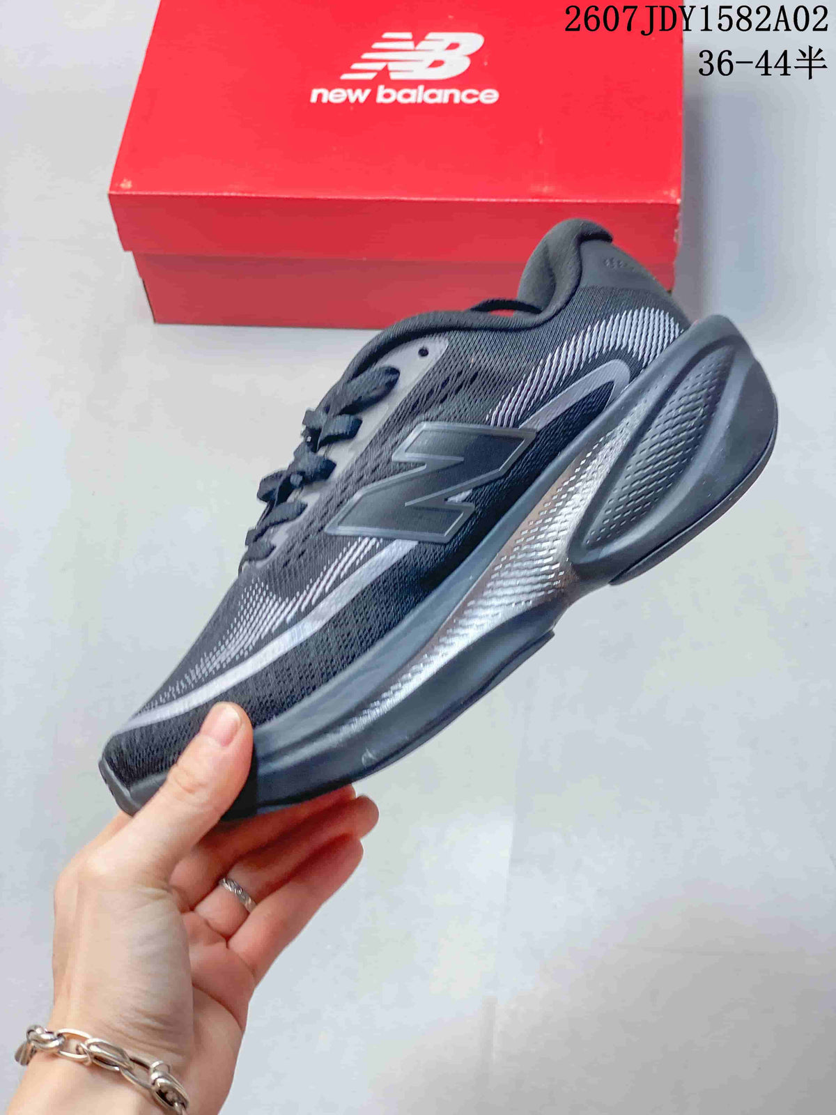 Side view of a dark gray New Balance running shoe with purple-toned patterned details