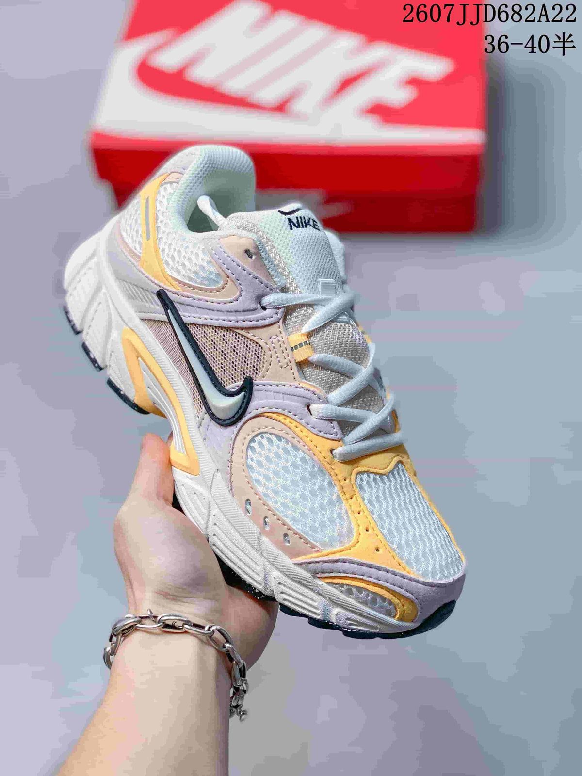 Angled front-side view of the Nike V5 RNR sneaker showing the layered upper, side Swoosh, white midsole and dark outsole; image text shows style code 2607JJD682A22 and size range 36–40.
