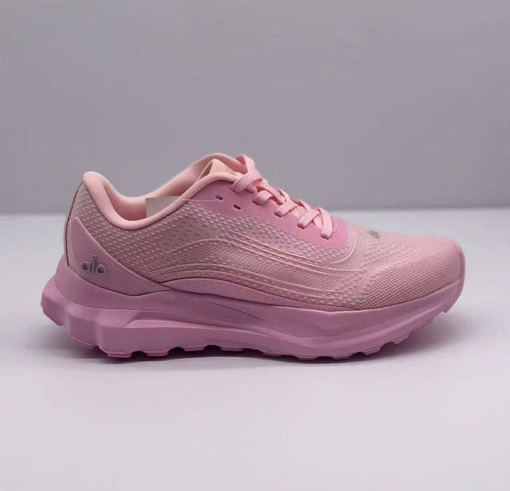 Side profile of pink Alo low-top sneakers showing the textured upper, laces, padded collar, and sculpted sole.