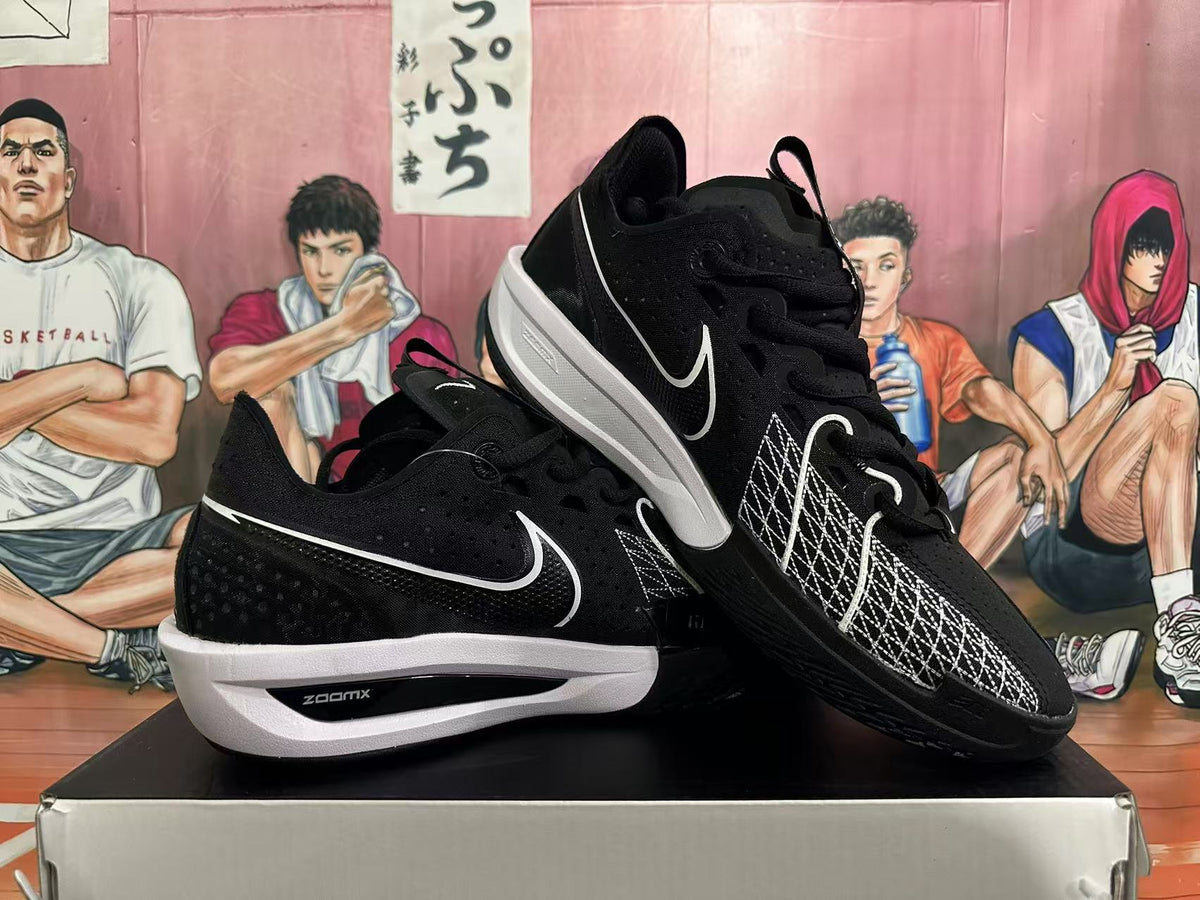 Angled view of black Nike basketball shoes with white accents and geometric forefoot stitching