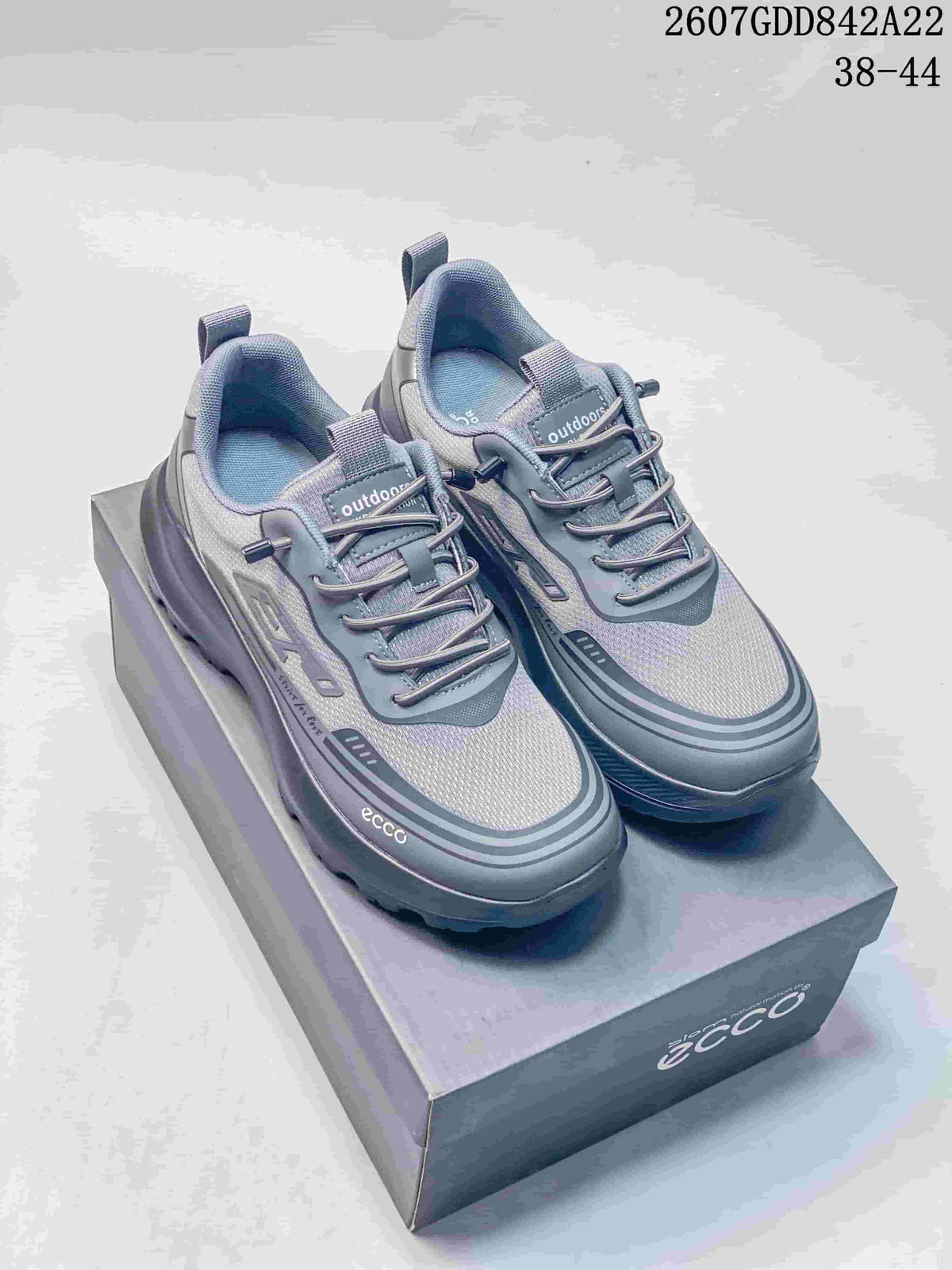 Pair of gray ECCO outdoor sneakers displayed on a shoebox, with model code 2607GDD842A22 and size range 38-44 visible above.
