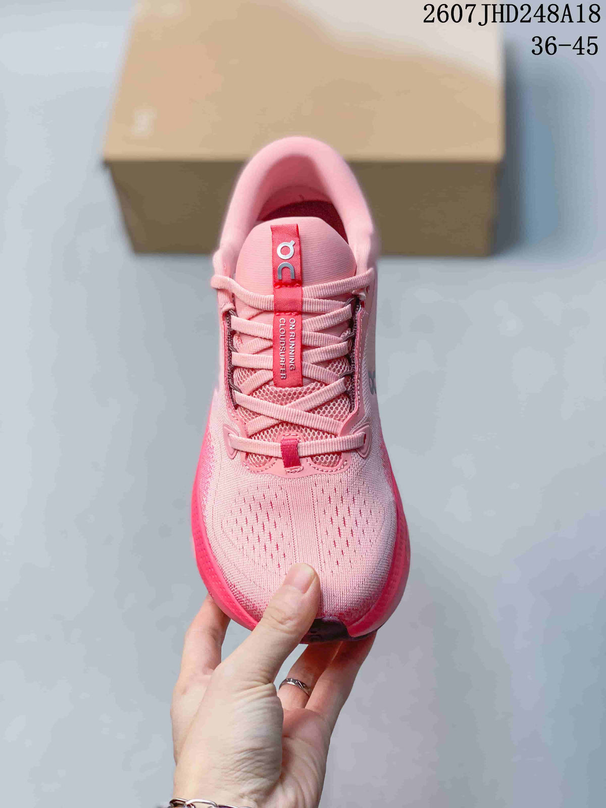 Top view of the pink sneaker showing the perforated toe area, laces, and tongue branding.