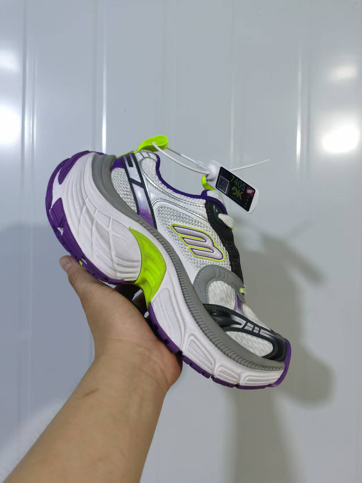 Angled close view of the Skechers 9157 sneaker highlighting the side logo, sculpted white midsole, lime accent and purple outsole.