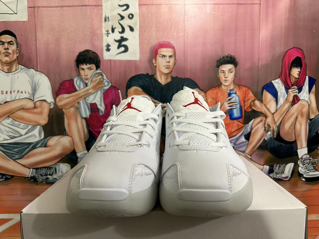 Front view of white lace-up basketball shoes with red tongue emblems