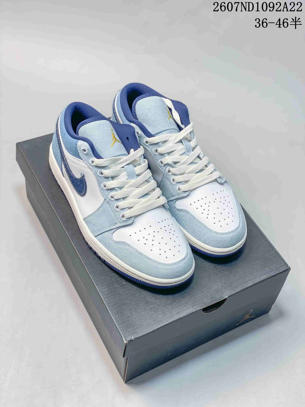 Pair of light blue, white, and dark blue low-top sneakers displayed on a shoebox; source code 2607ND1092A22 and size range 36–46.5 are visible.