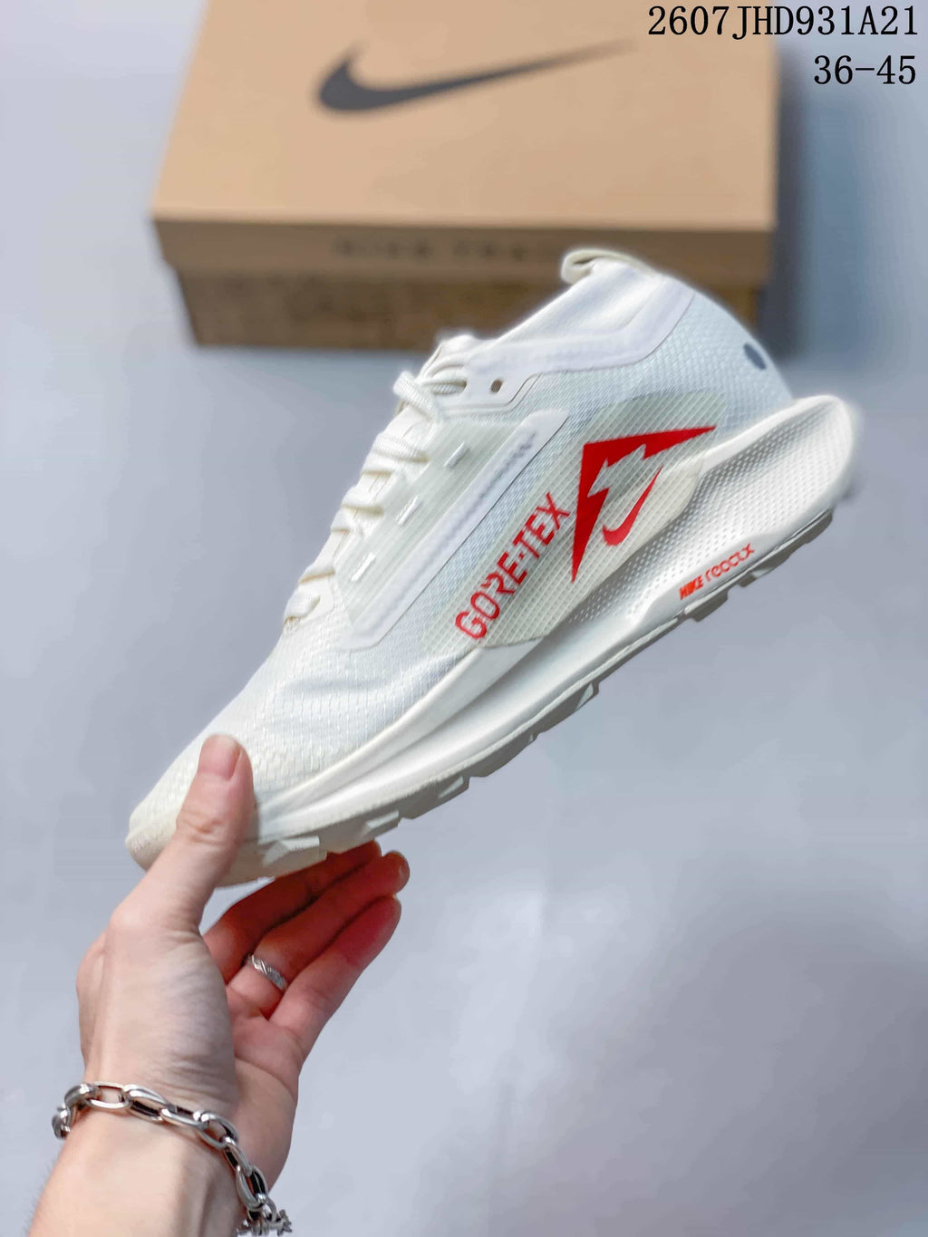 Side view of the white sneaker showing visible Gore-Tex branding, a Nike Swoosh, and red outsole detailing.