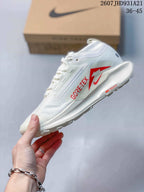 Side view of the white sneaker showing visible Gore-Tex branding, a Nike Swoosh, and red outsole detailing.