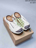 Pair of Salomon RX Slide 3.0 closed-toe slip-ons displayed on a branded box, showing the white upper, green check-pattern panels and dark trim.