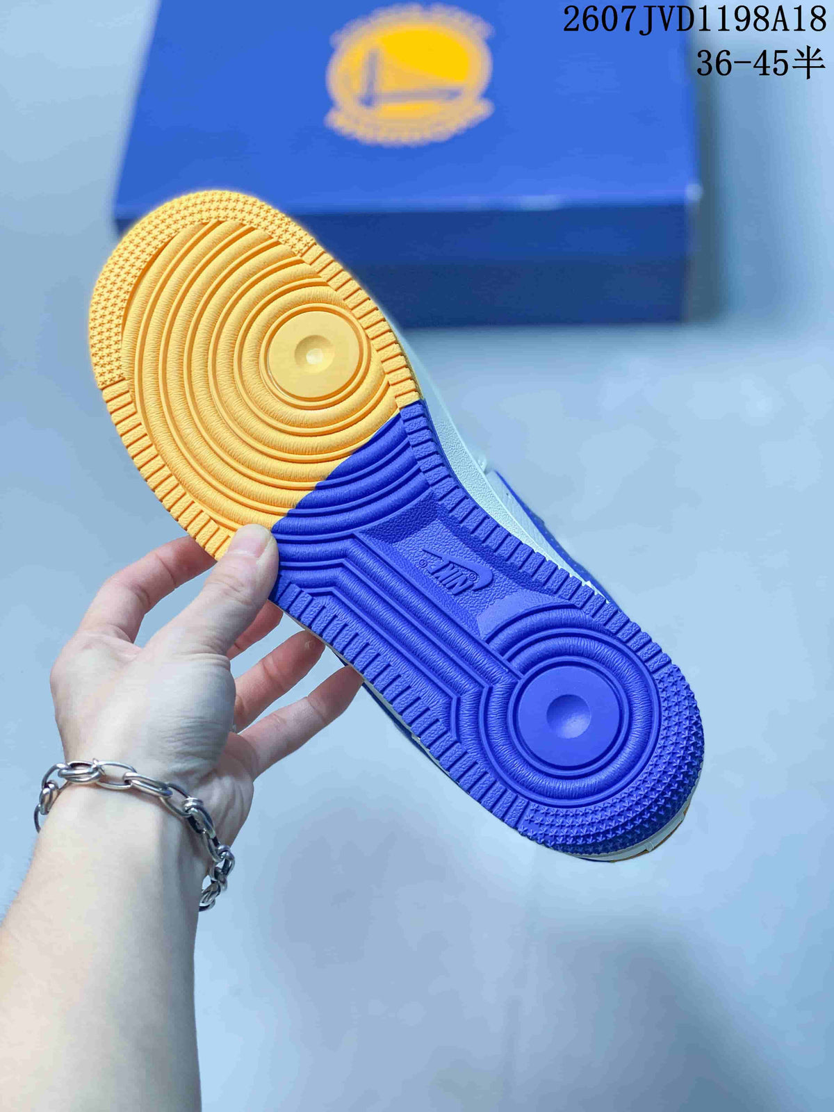 Close-up of the sneaker outsole showing blue and yellow sections with circular traction details.