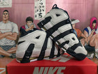 Angled view of white and dark navy Nike basketball shoes with oversized AIR lettering.
