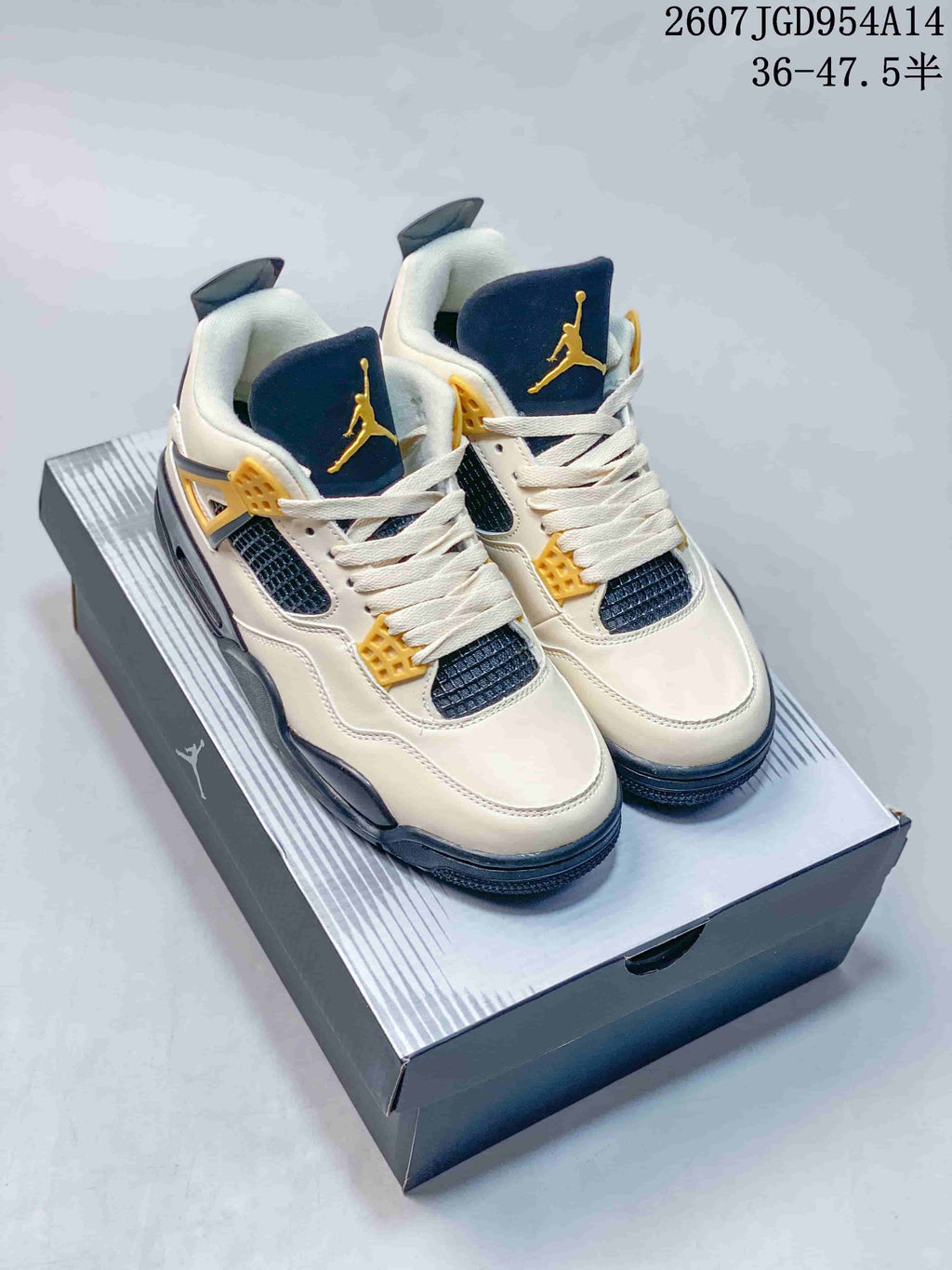 Pair of off-white Jordan Air Jordan 4 Retro sneakers with navy and gold accents displayed on a shoebox.