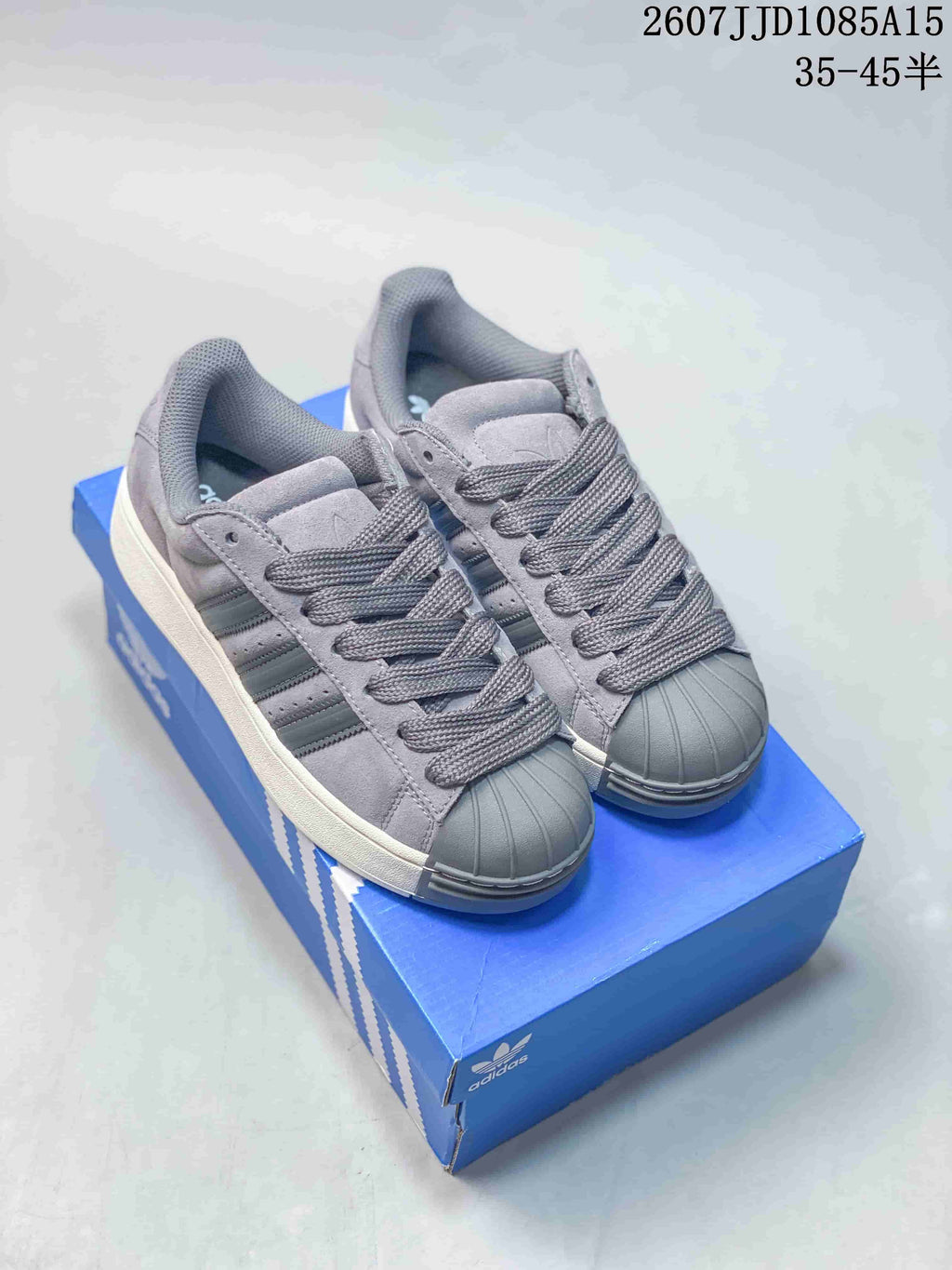 Gray adidas shell-toe sneakers with gray laces and a light-colored sole.