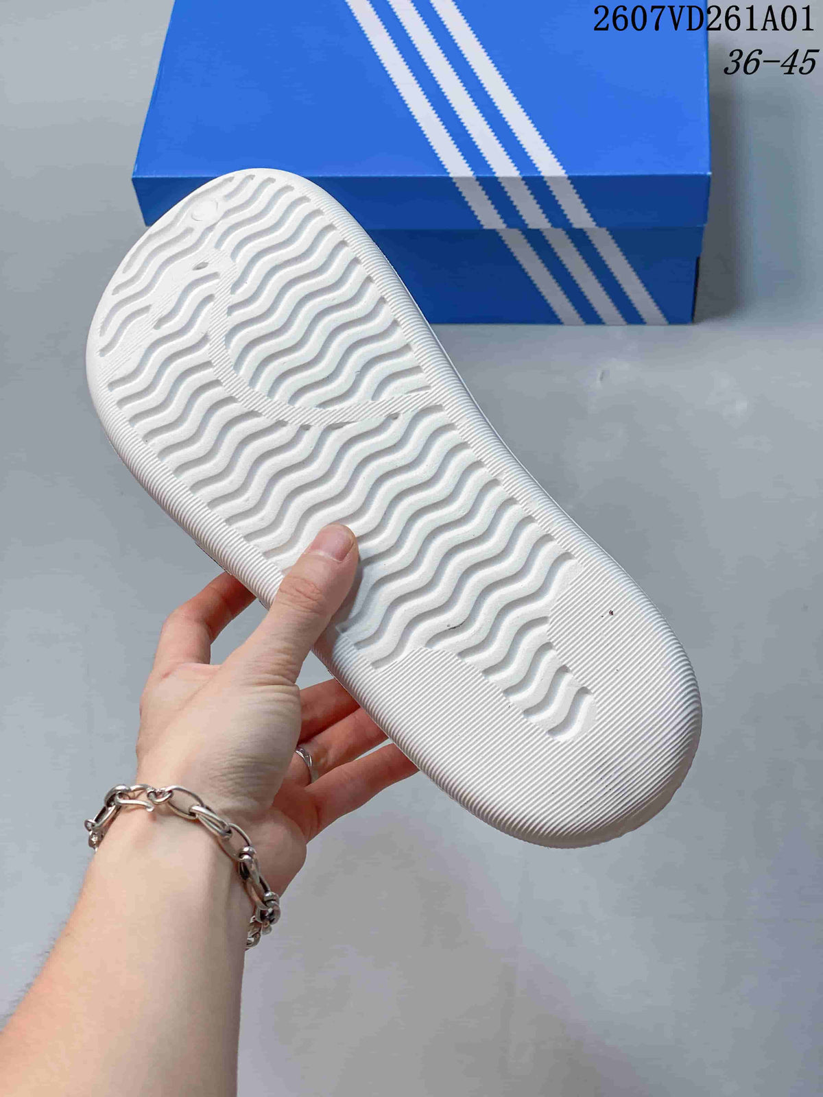 Underside of a white mule slide showing its wavy tread pattern