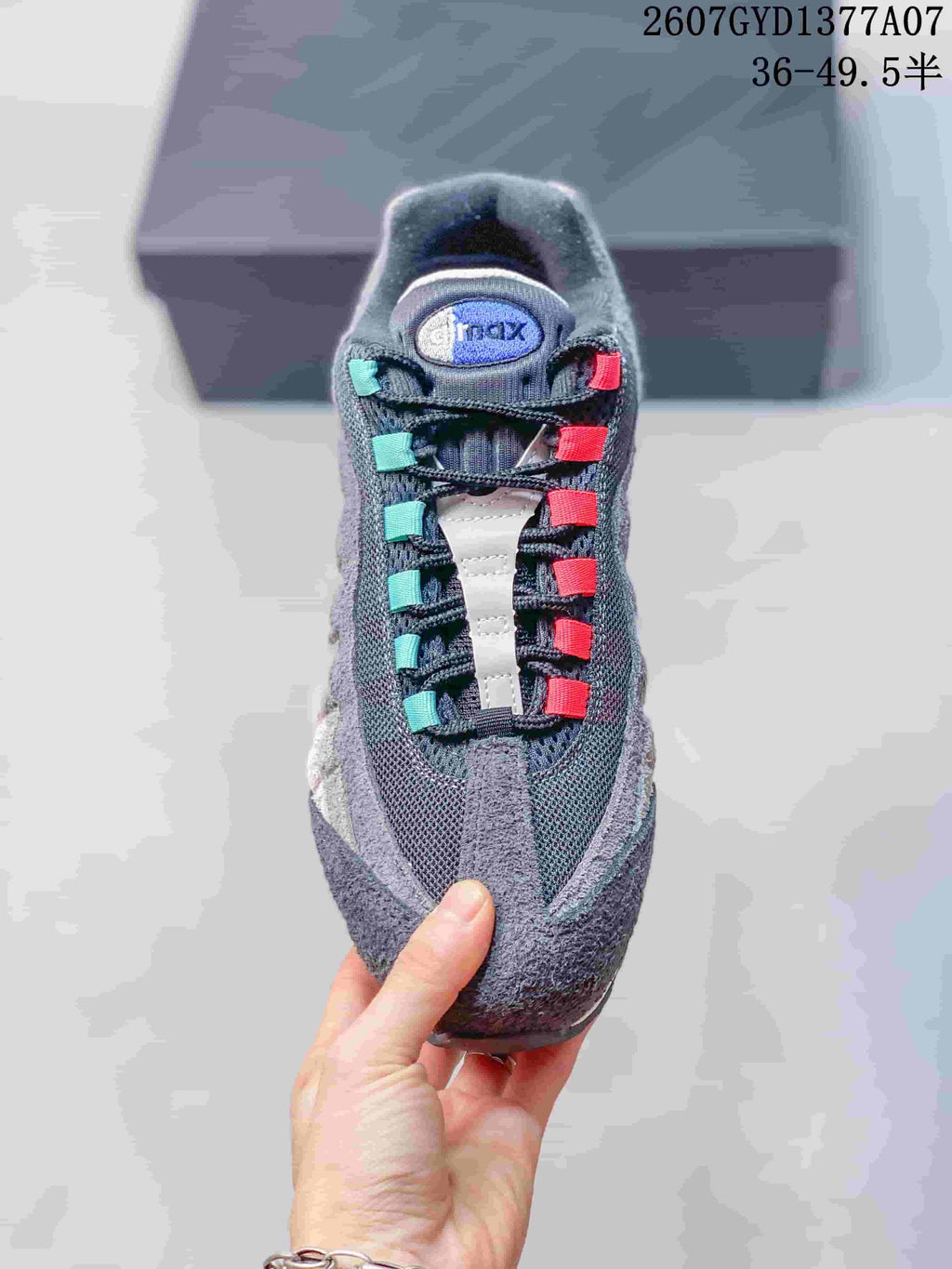 Top view of a Nike Air Max 95 sneaker showing the layered upper and contrasting teal and pink lace loops.