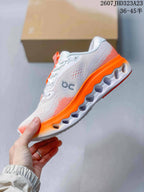 Side view highlighting the white perforated upper, On branding, orange midsole, and sculpted outsole.