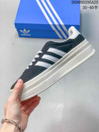 Side view showing the dark navy upper, white three-stripe detailing, and thick layered platform sole.