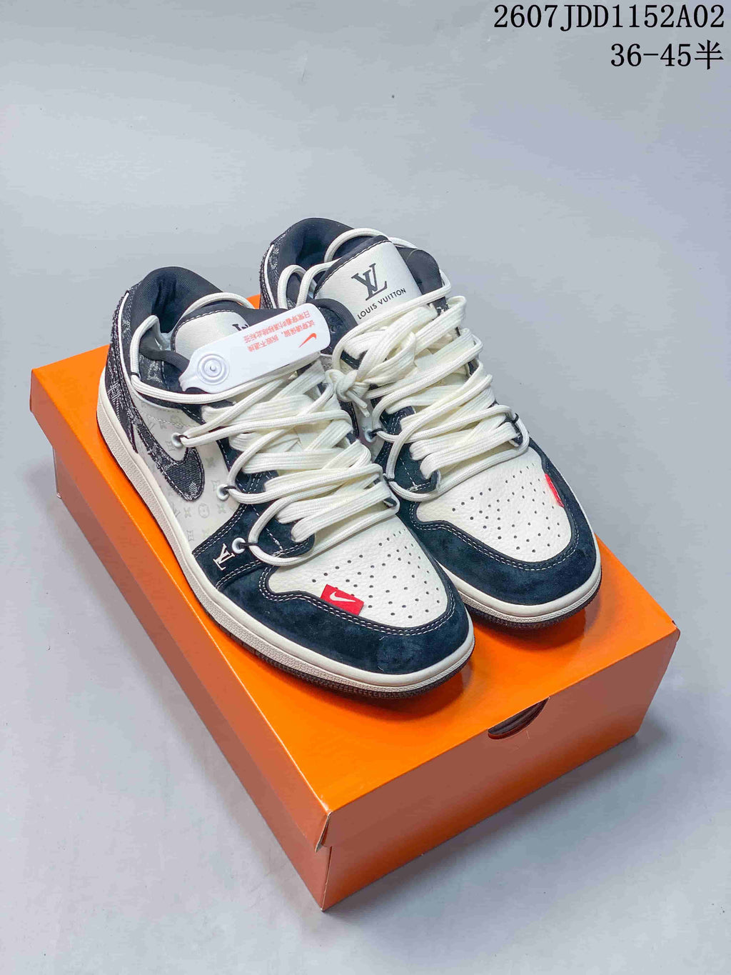 Pair of white and dark blue patterned low-top sneakers on an orange box
