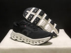 Angled view showing the black outsole tread and open midsole structure of the sneakers.