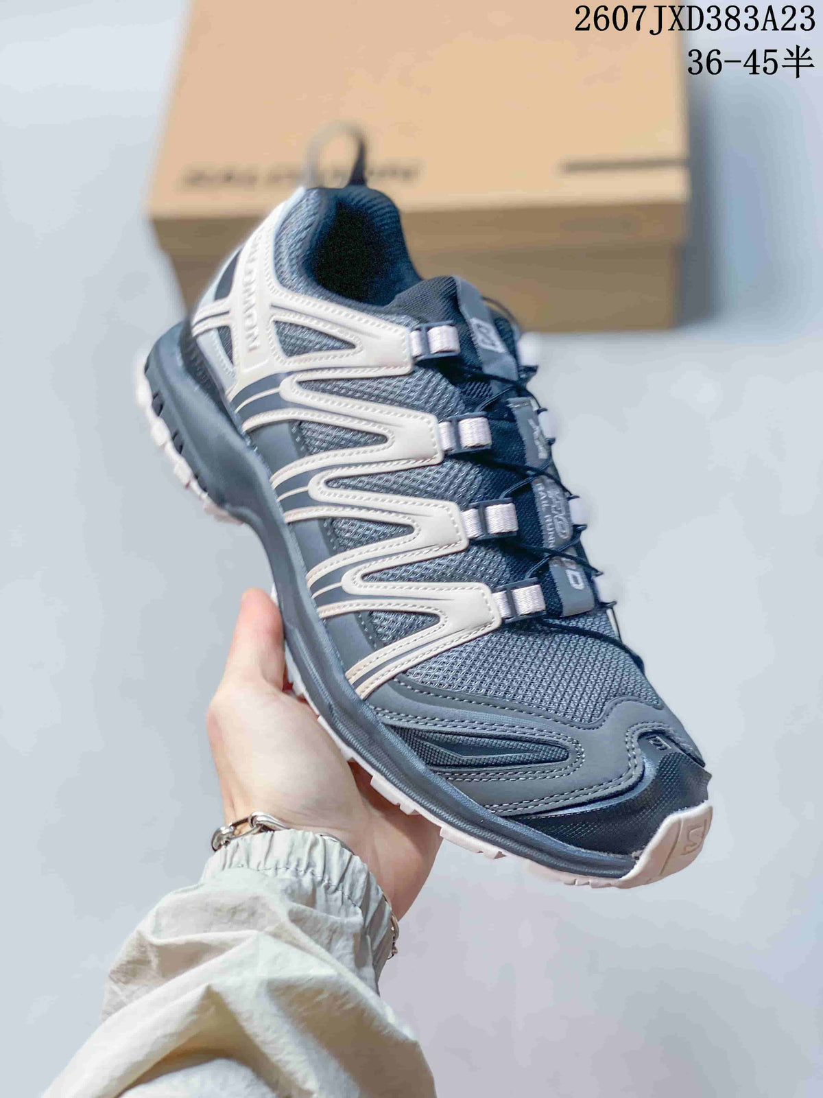Three-quarter side view showing the ash gray upper, layered side panels, heel structure, and contrasting outsole.
