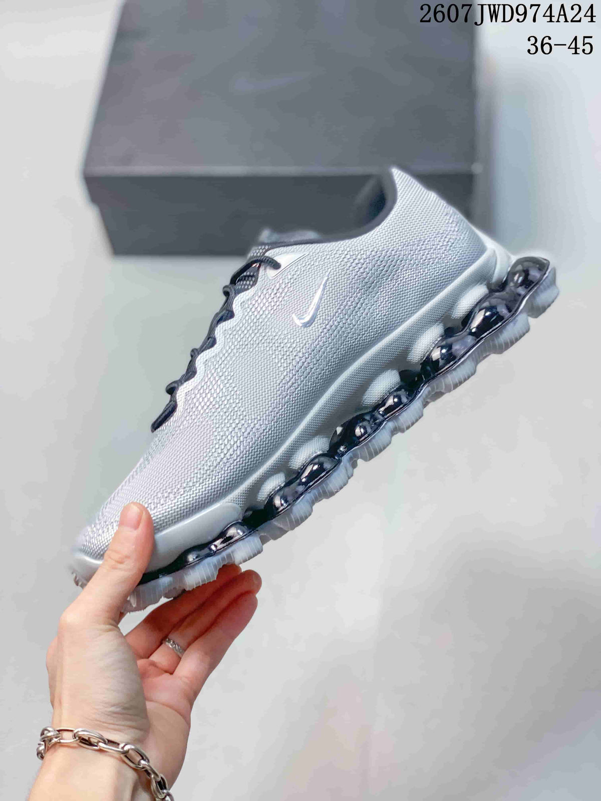 Side view of a silver-gray Nike Air Liquid Max sneaker with a white upper edge and segmented dark-and-white outsole.