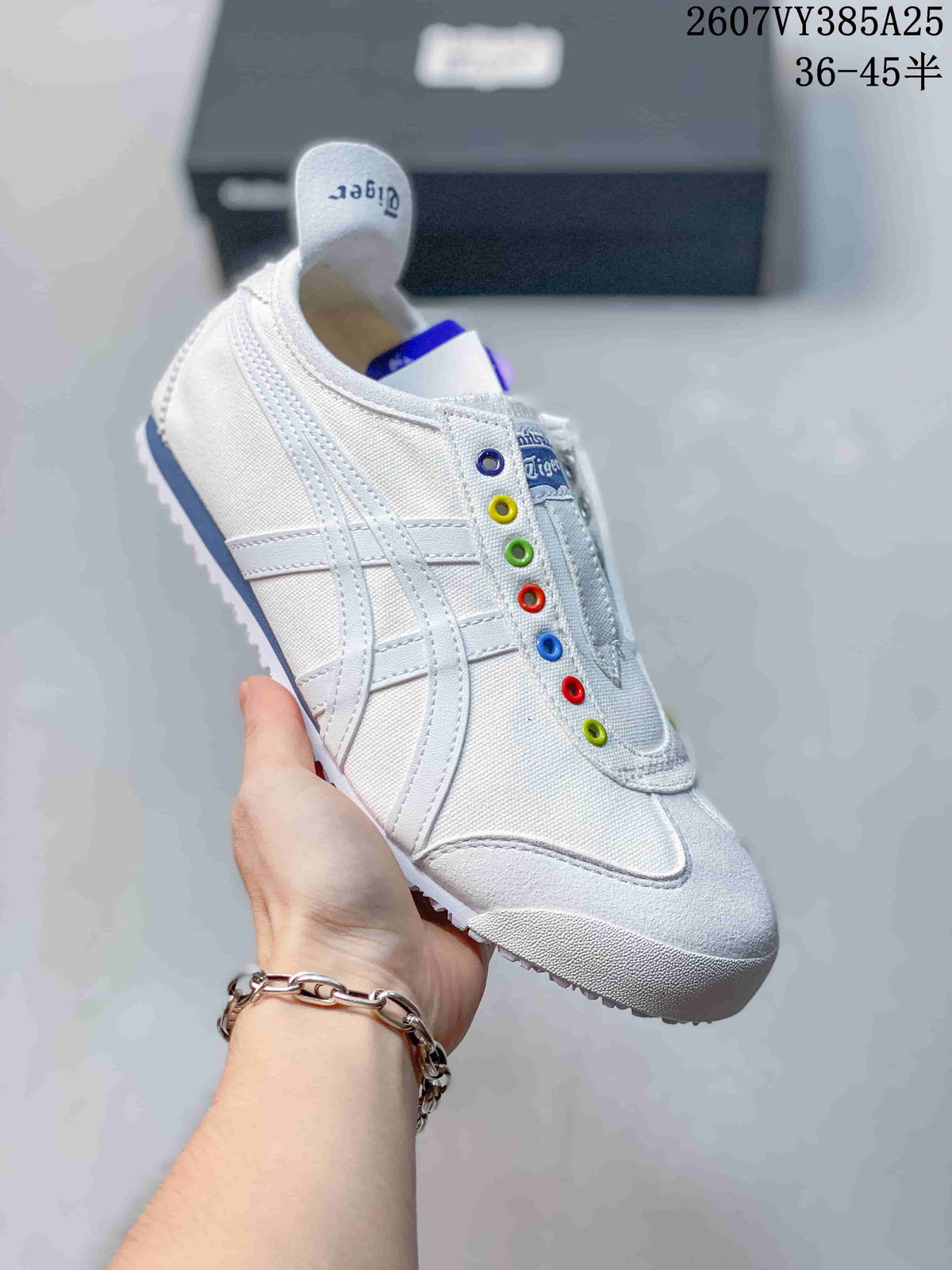 White Onitsuka Tiger slip-on sneaker with colorful eyelets and white side stripes.