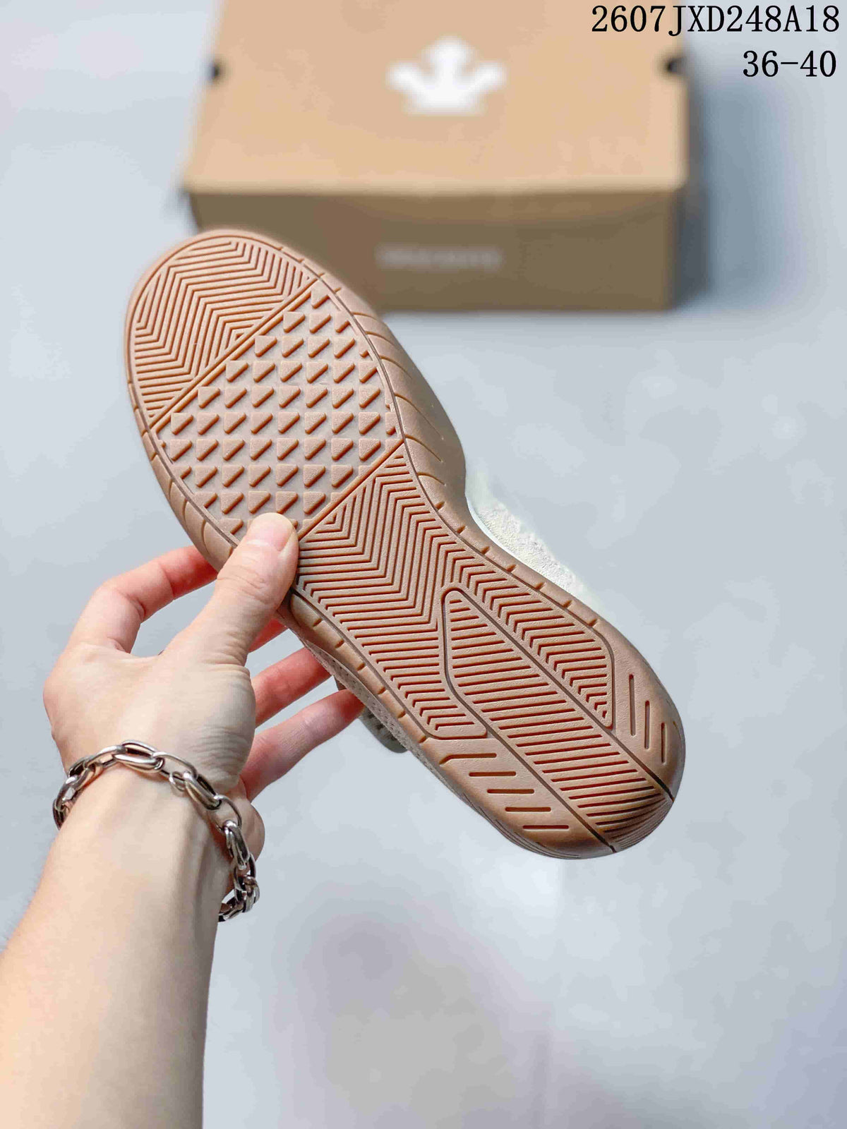 Close view of the sneaker outsole showing a gum-colored patterned tread.