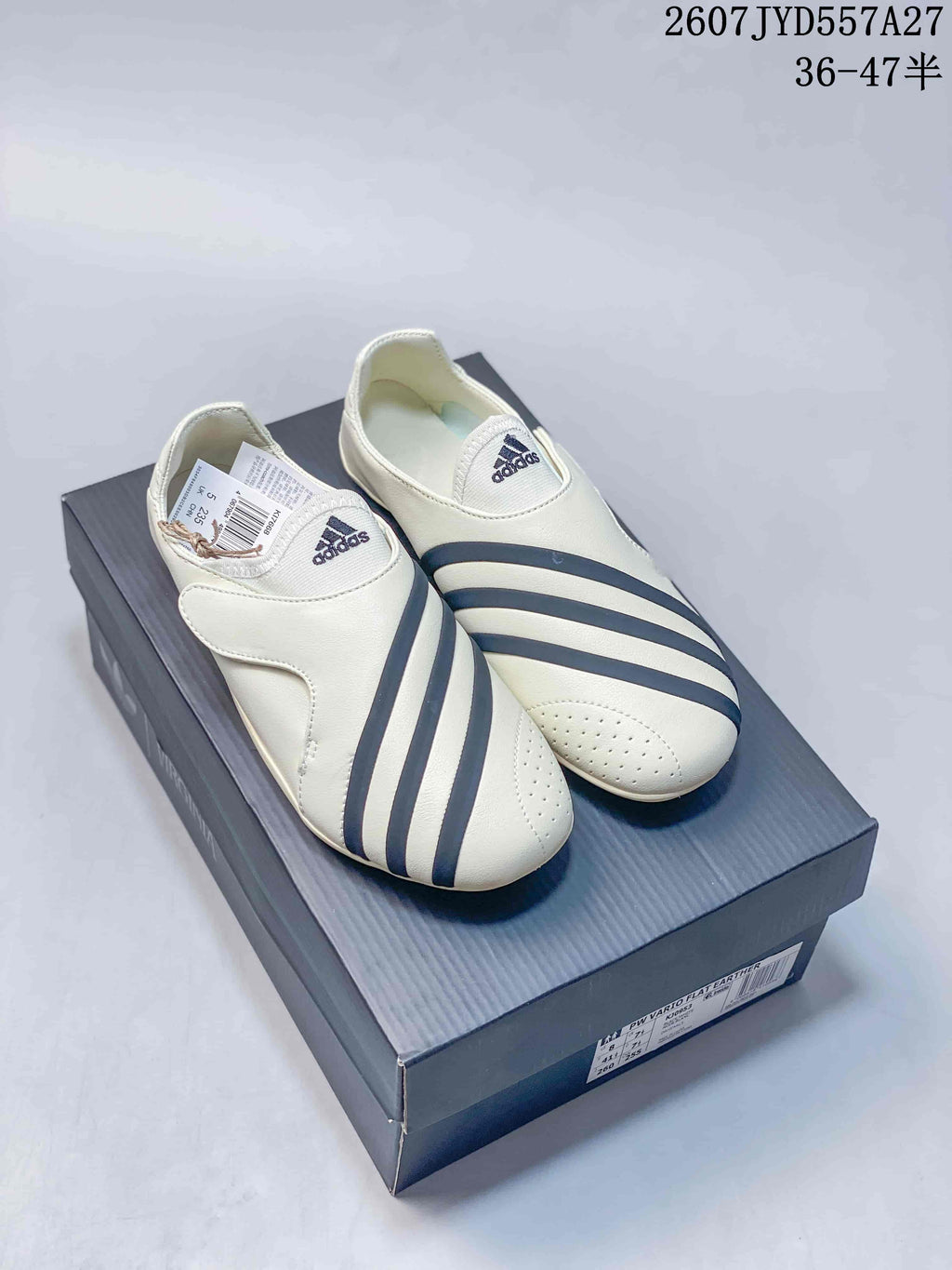 Pair of off-white adidas sneakers with navy stripes displayed on a shoebox; size range text is visible at the top.