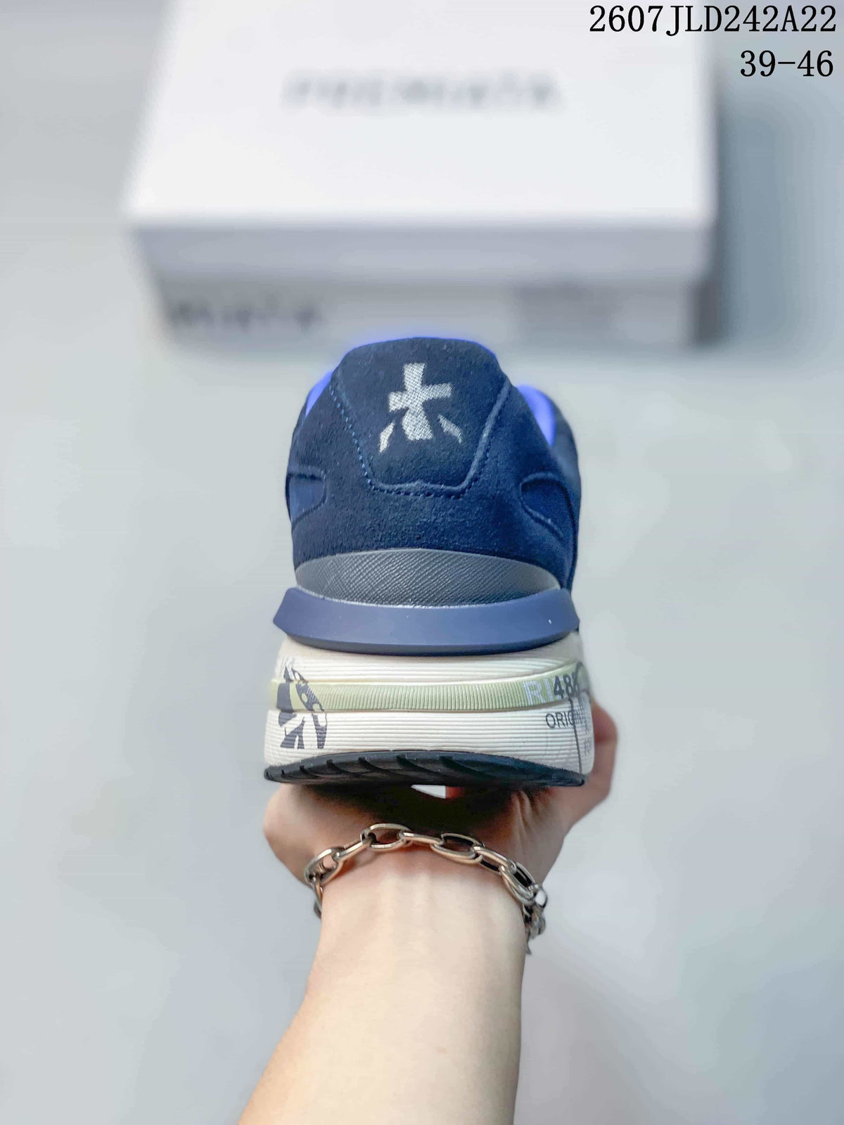 Rear view of the navy blue trainers showing the padded heel, white logo detail and printed midsole graphics.