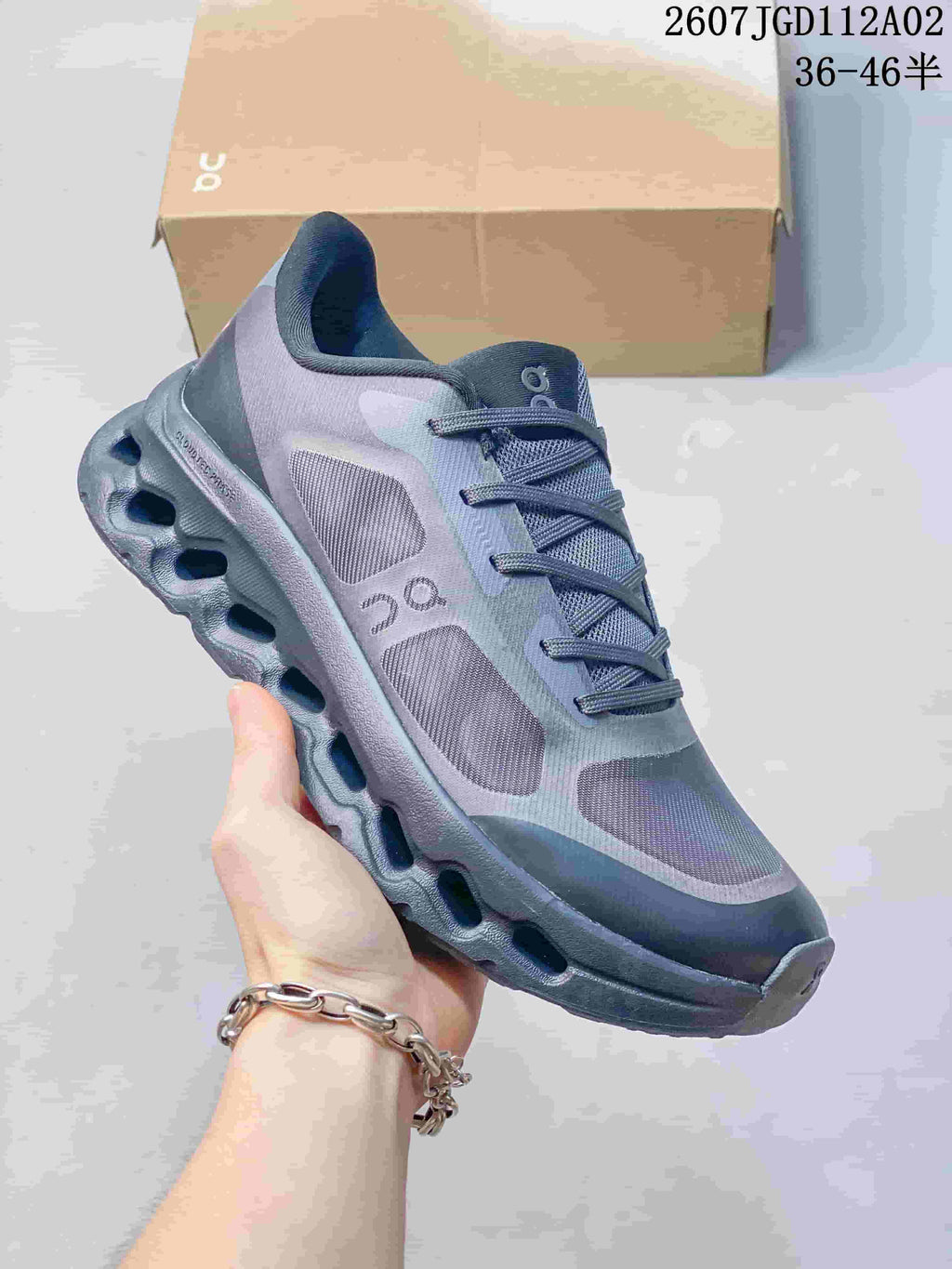 Close-up of a dark grey Cloudtilt Remix sneaker showing the side panels and sculpted sole