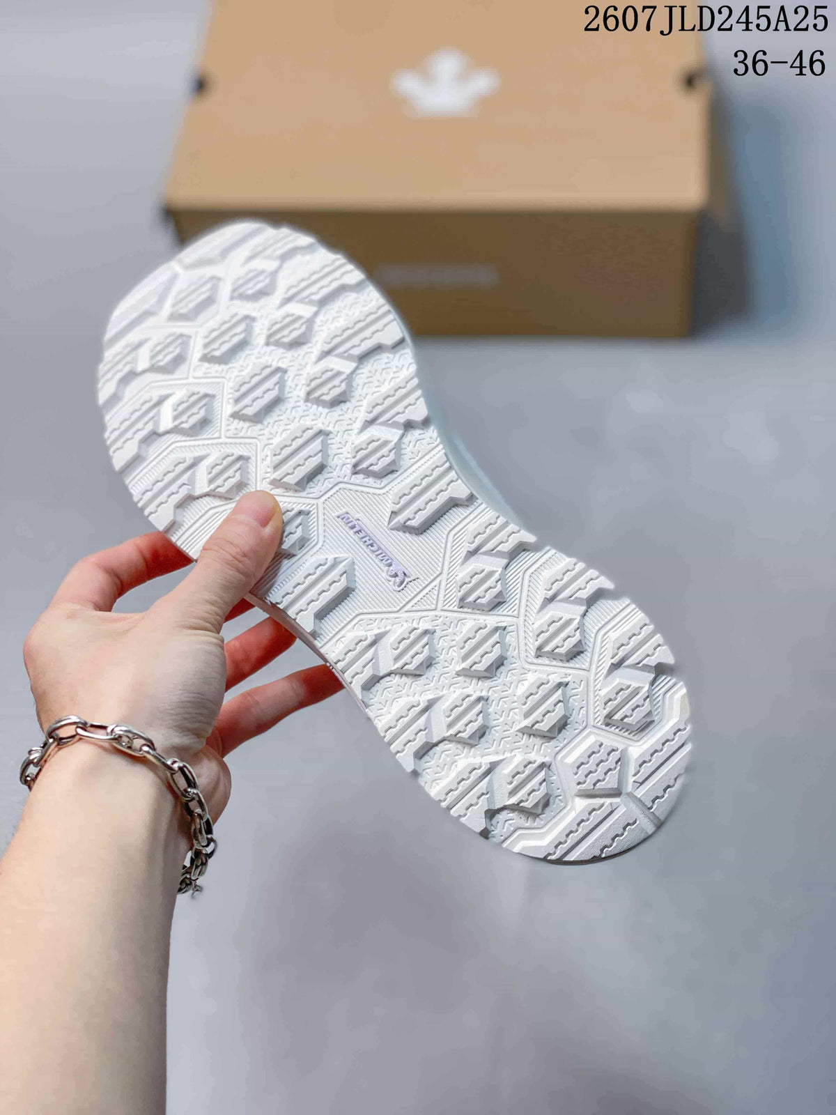 White sneaker outsole shown from below, featuring a geometric patterned tread.