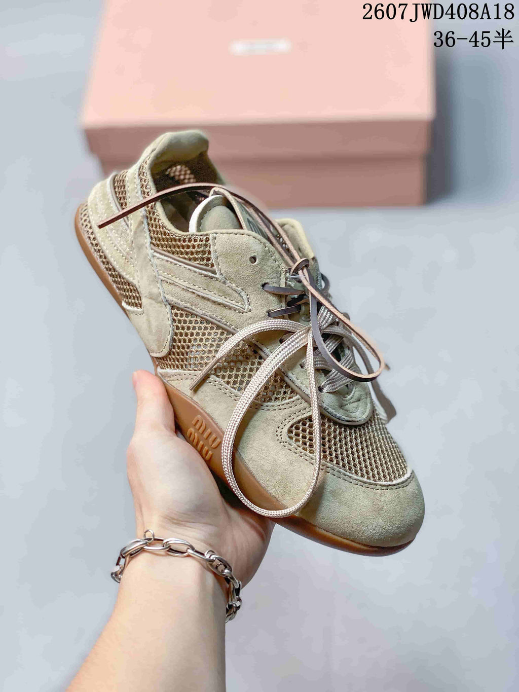 Three-quarter view of one beige-sage sneaker showing the layered side panels, mesh inserts, laces, and textured outsole.