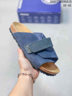 Angled close-up of the navy sandal showing the adjustable strap, open toe, footbed, cork-look midsole, and textured outsole.