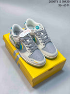 Pair of white and gray low-top sneakers with turquoise and yellow accents on a yellow box.