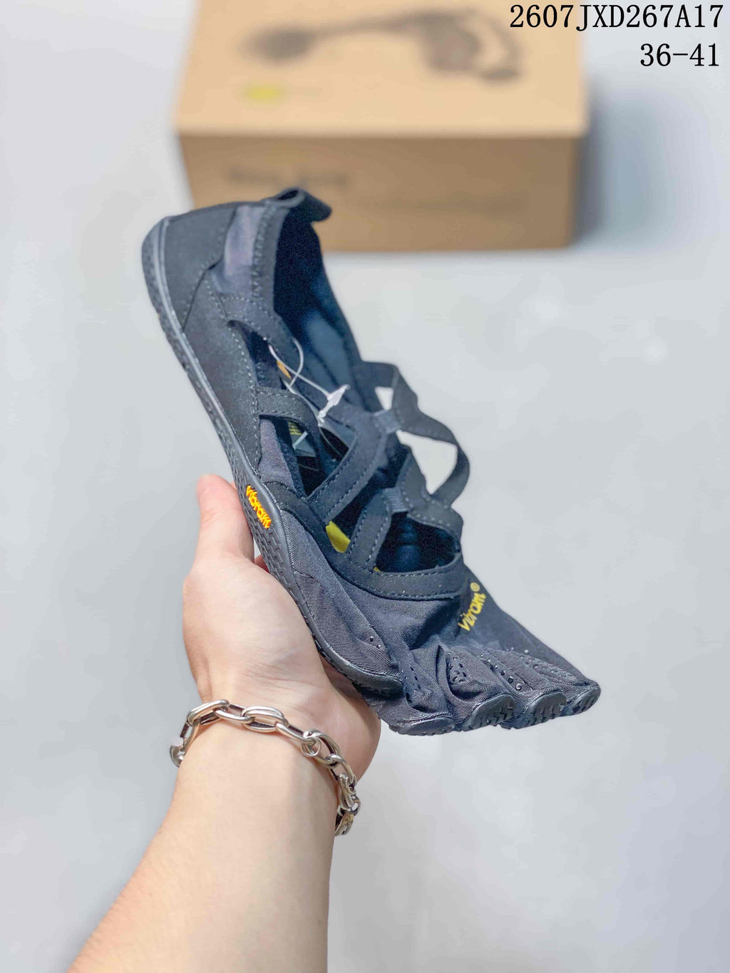 Angled side view of the dark gray five-finger sneaker with yellow Vibram branding and a textured sole.
