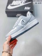 Side profile showing the white layered upper, dark Swoosh detail, raised midsole, and textured outsole.