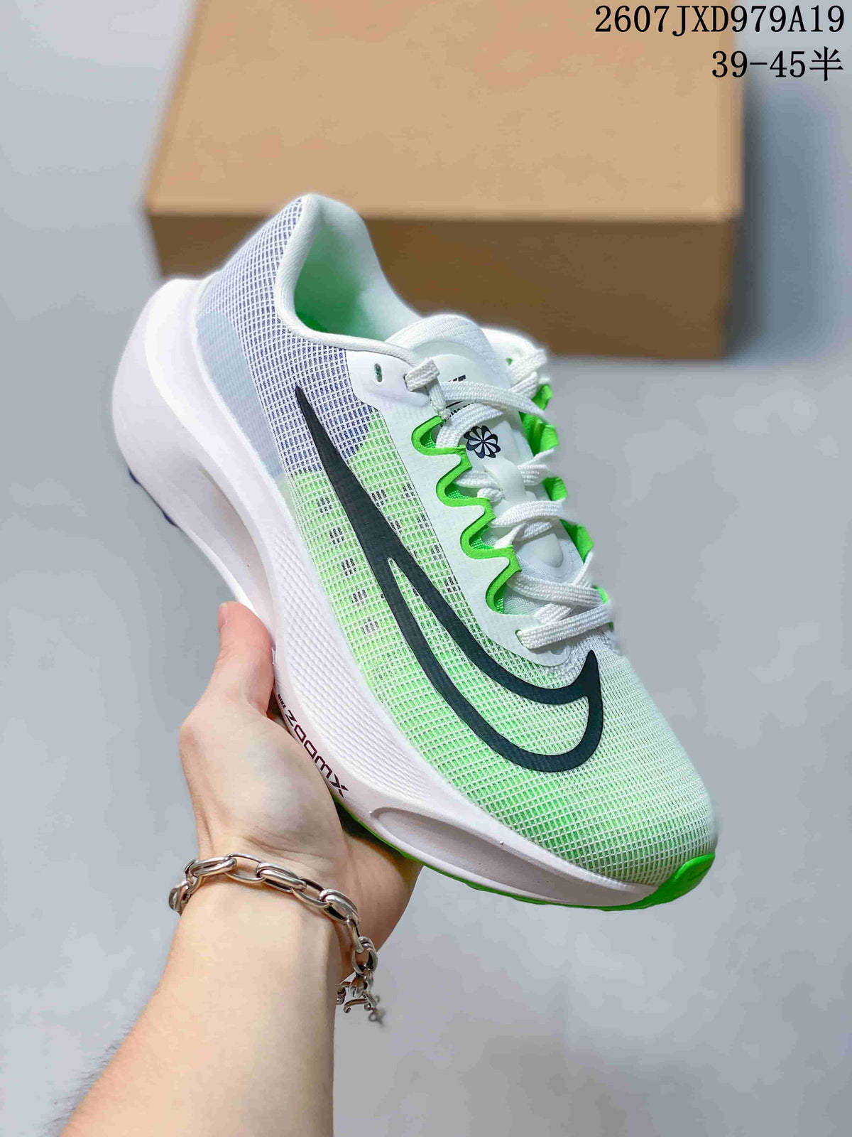 Angled side view of a white Nike running sneaker showing its textile-style upper, black branding and green outsole accents.