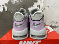 Rear view of gray and lavender Nike sneakers with silver swooshes and visible heel cushioning.
